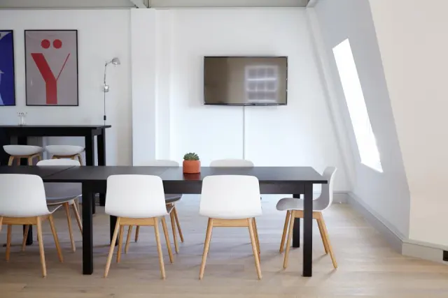 Minimal, light-filled consultation room with white chairs