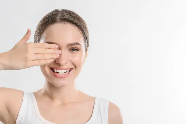 Woman smiling warmly with one hand raised near her face